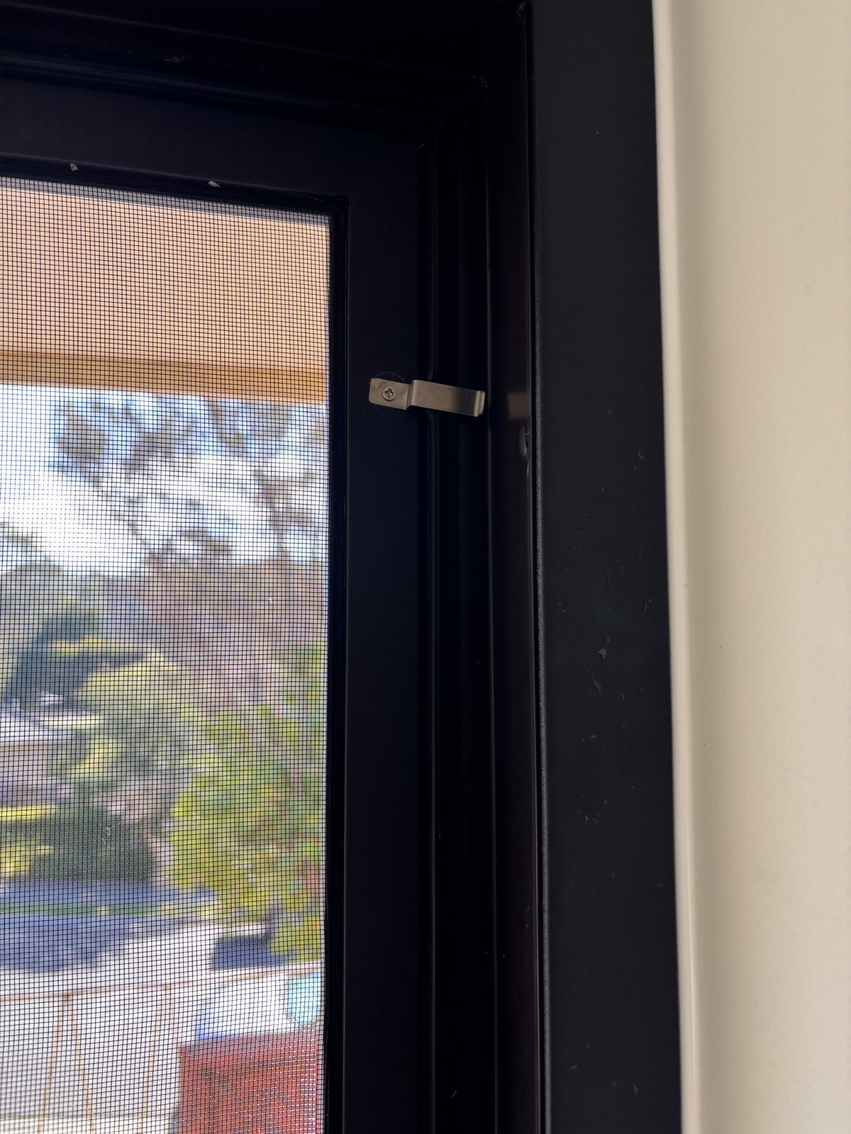 Colour matched fixed flyscreen fitted to a black uPVC window frame