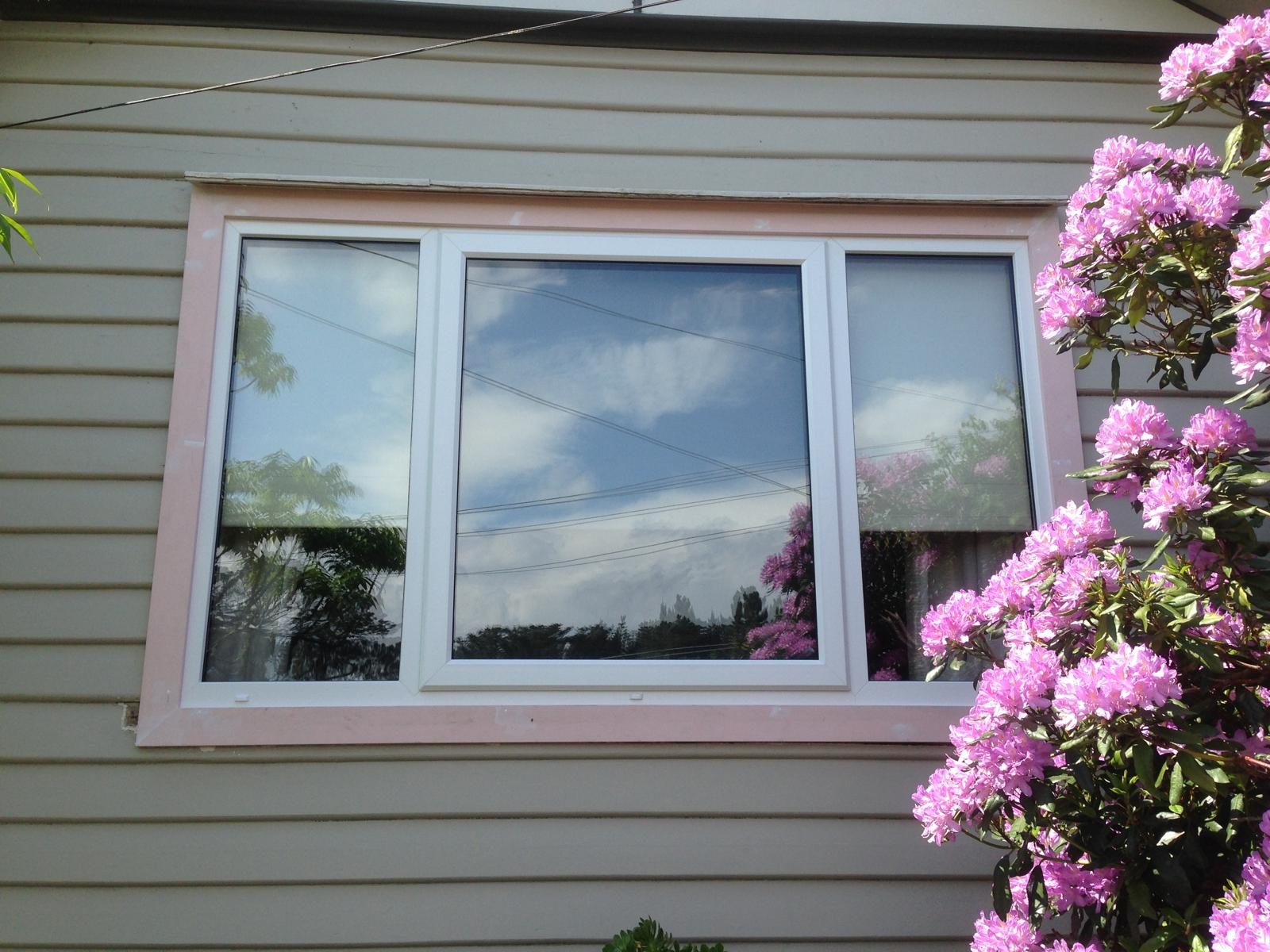 White uPVC window framed by flowering garden