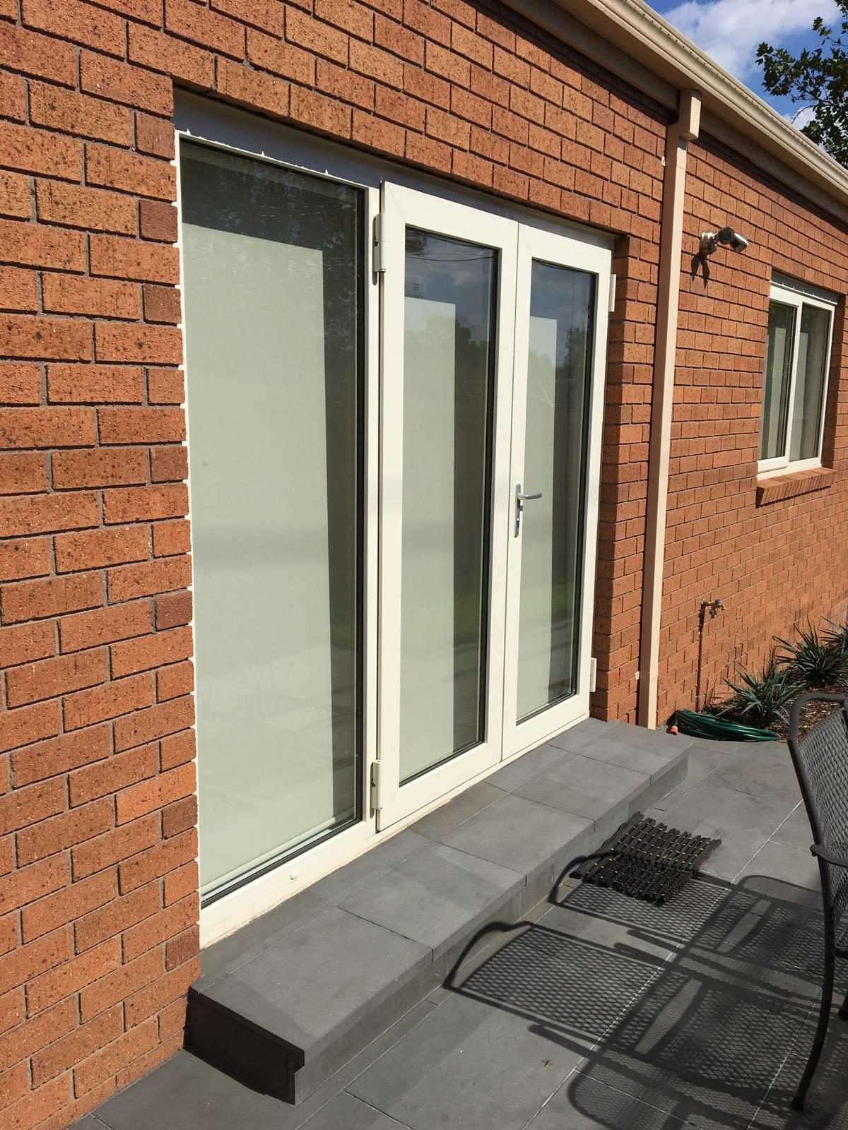 White sliding door set in a brick wall