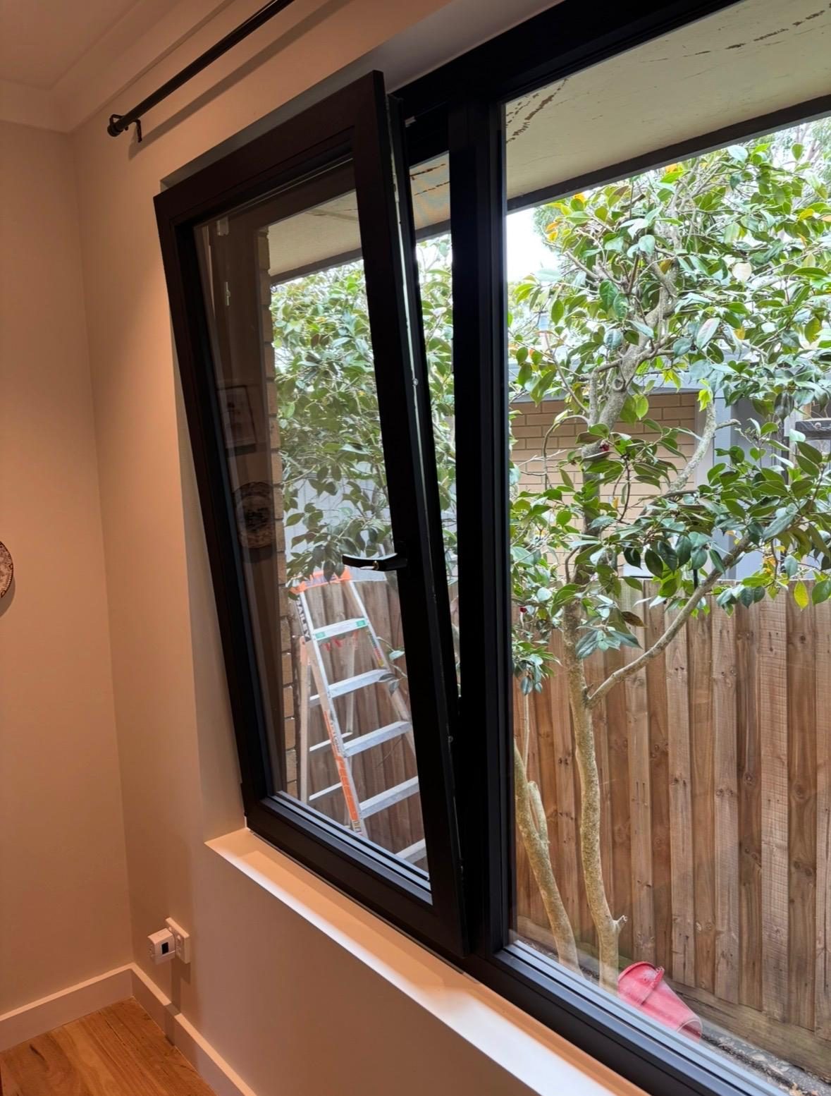 Black uPVC awning window viewed from inside a living room