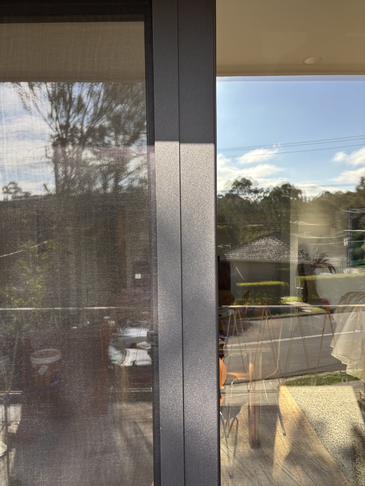 Colour matched flyscreen on a black double glazed uPVC window