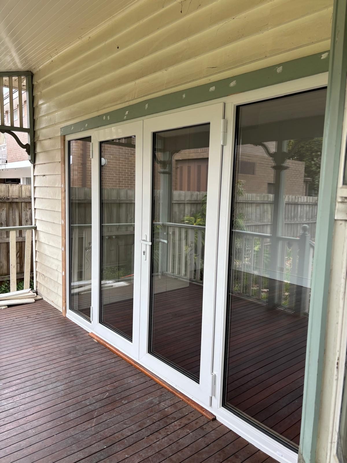 White uPVC sliding doors opening to a timber verandah
