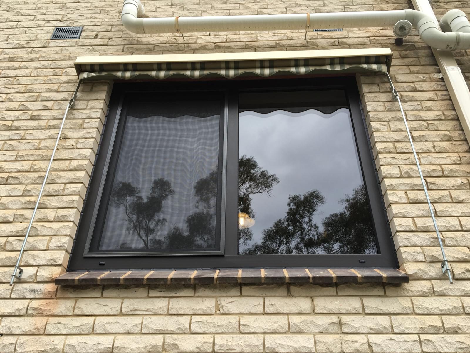 Dark framed double glazed window with treed outlook